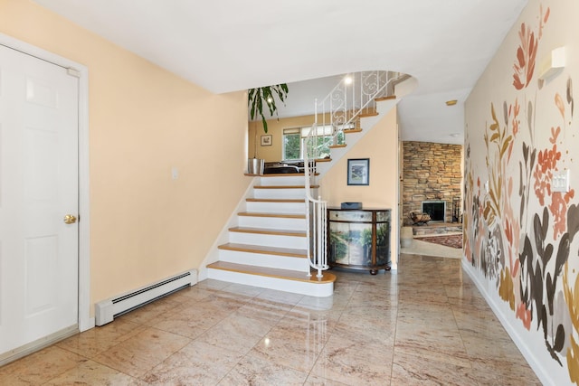 entryway featuring stairway, a stone fireplace, a baseboard heating unit, and baseboards