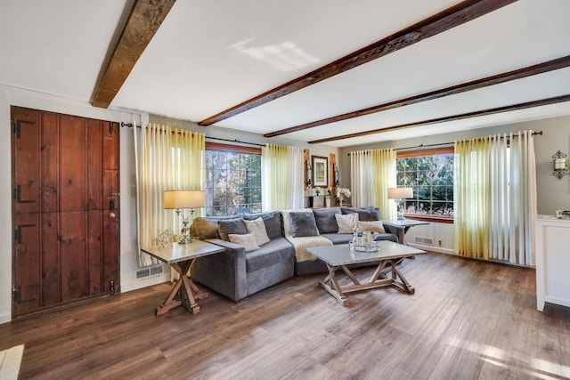 living area with beamed ceiling, visible vents, and wood finished floors