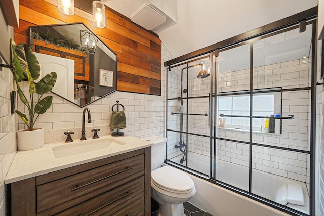 full bath featuring tasteful backsplash, bath / shower combo with glass door, vanity, and toilet