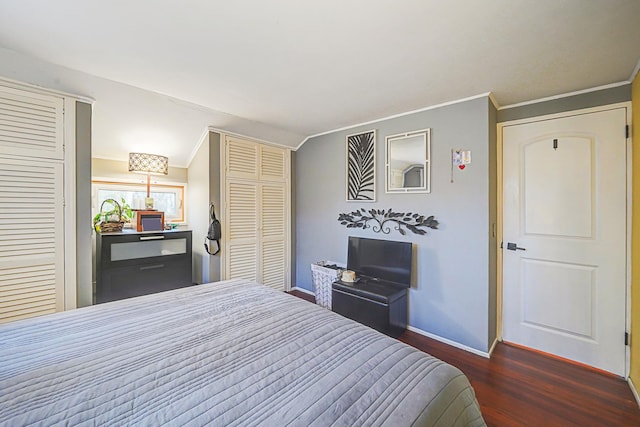 bedroom featuring baseboards, wood finished floors, and crown molding