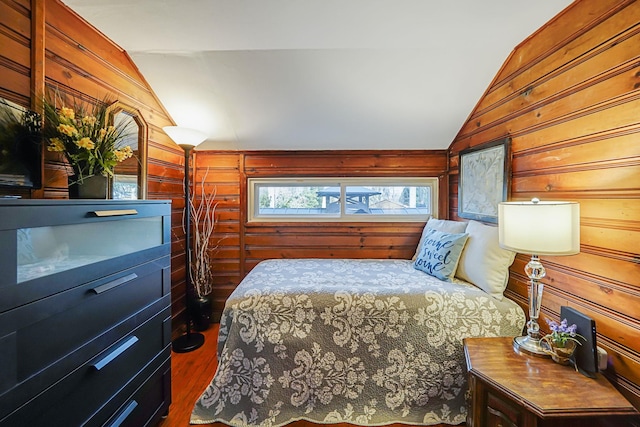 bedroom featuring vaulted ceiling, dark wood-type flooring, and wood walls