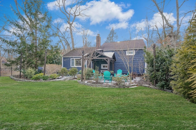 back of house with a chimney and a yard