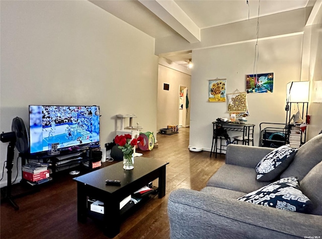 living area featuring beamed ceiling and wood finished floors