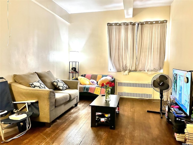 living room featuring hardwood / wood-style floors, beamed ceiling, and radiator heating unit