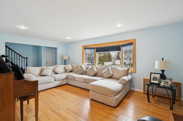 living area with stairway, recessed lighting, baseboards, and light wood-type flooring