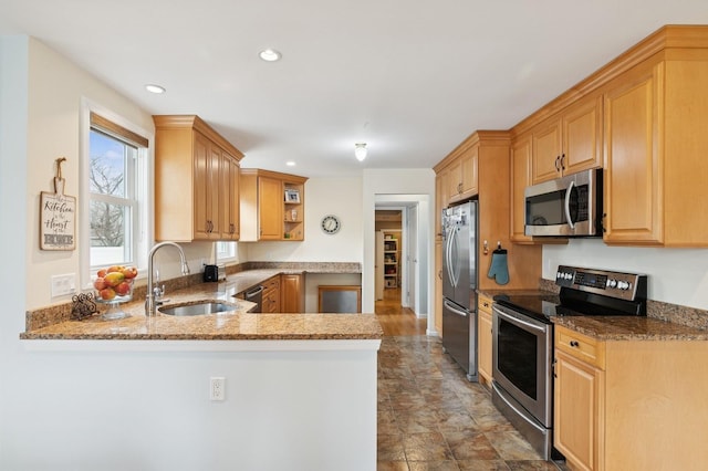 kitchen featuring a sink, appliances with stainless steel finishes, a peninsula, stone countertops, and open shelves