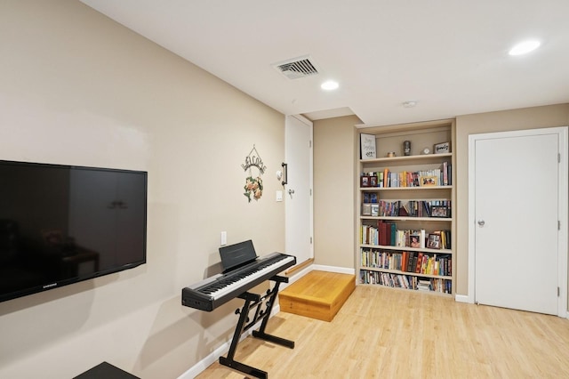 workout area with visible vents, recessed lighting, baseboards, and wood finished floors