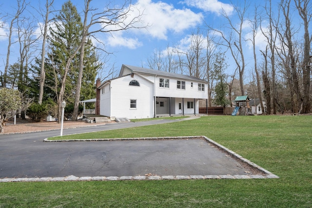 view of front facade with a front lawn and a playground