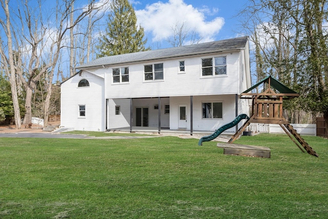 back of house with a patio area, a lawn, and a playground