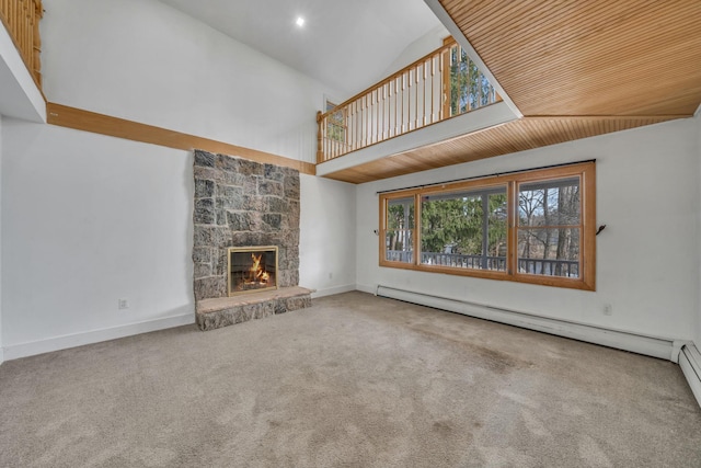 unfurnished living room featuring baseboards, high vaulted ceiling, a fireplace, carpet flooring, and baseboard heating