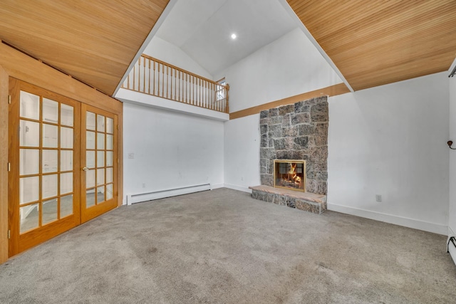 unfurnished living room with french doors, a fireplace, a baseboard heating unit, and carpet floors