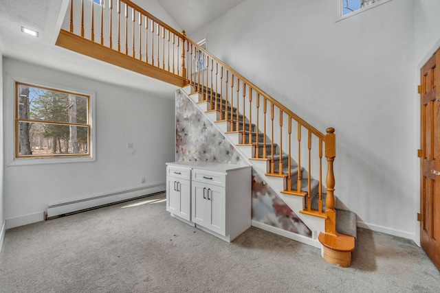 staircase featuring carpet floors, baseboards, baseboard heating, and high vaulted ceiling