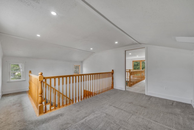 bonus room featuring vaulted ceiling, baseboards, carpet floors, and a textured ceiling