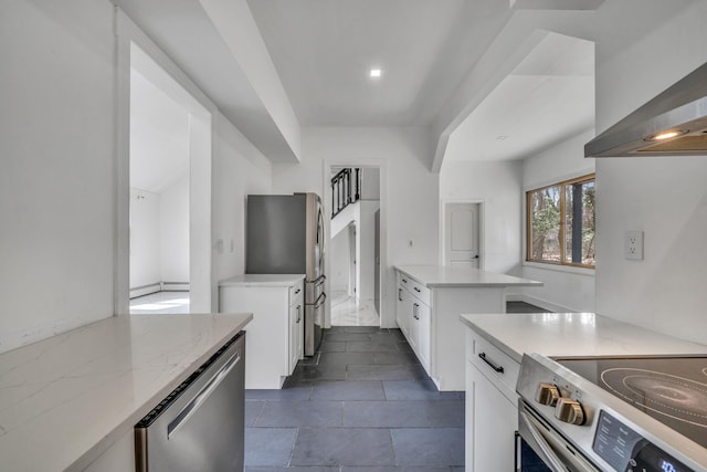 kitchen featuring light stone counters, white cabinetry, appliances with stainless steel finishes, and wall chimney range hood