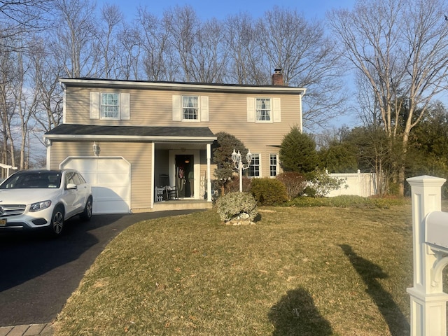 view of front of property with an attached garage, a front lawn, a chimney, and driveway