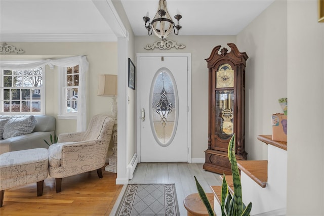 entrance foyer with light wood-style flooring, a notable chandelier, baseboards, and baseboard heating