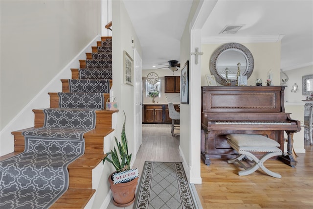 interior space featuring visible vents, crown molding, a ceiling fan, and wood finished floors