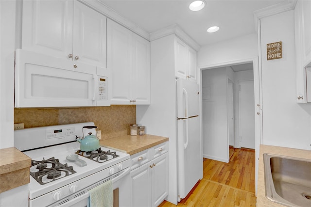 kitchen featuring a sink, white appliances, white cabinetry, and light countertops