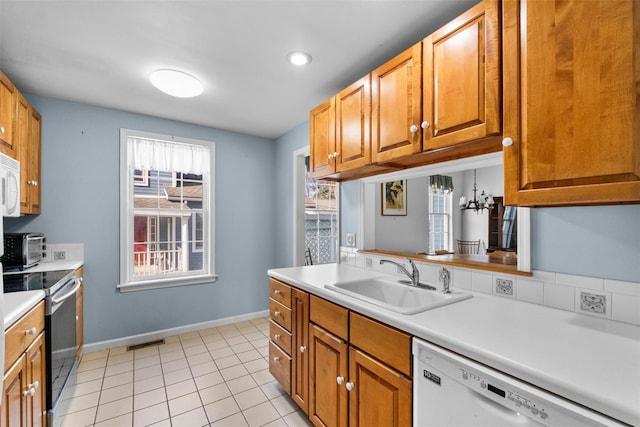 kitchen featuring visible vents, stainless steel electric stove, dishwasher, light countertops, and a sink