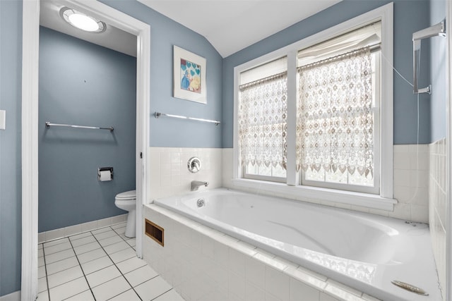 full bath with tile patterned floors, a garden tub, toilet, baseboards, and vaulted ceiling