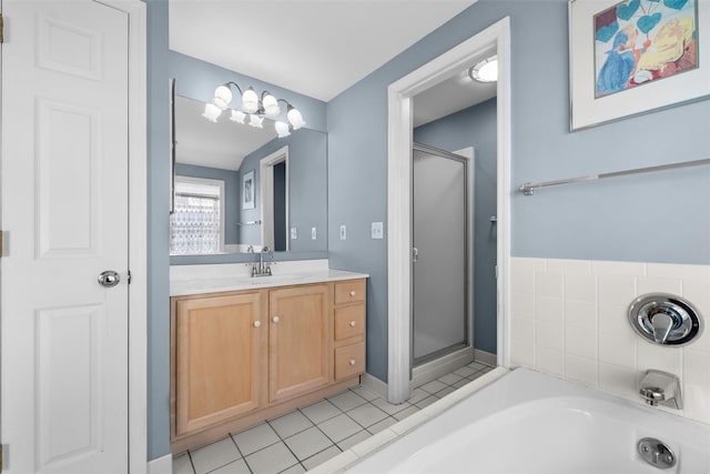 bathroom featuring vanity, a shower stall, a garden tub, and tile patterned floors