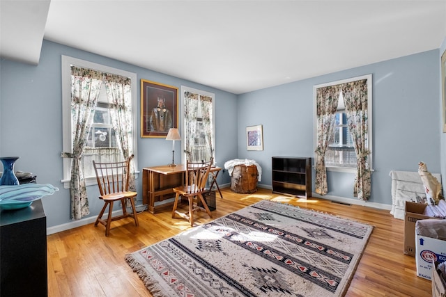 office space with plenty of natural light, wood finished floors, and baseboards