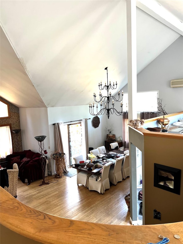 dining room with a wall mounted air conditioner, lofted ceiling, and wood finished floors