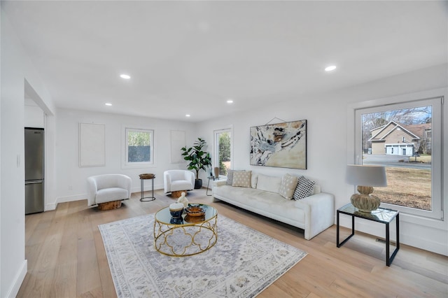 living area featuring recessed lighting, baseboards, and light wood-style floors