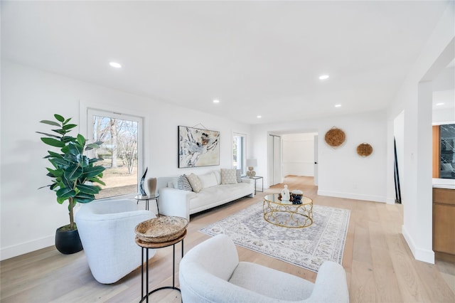 living area with a wealth of natural light, recessed lighting, light wood-style flooring, and baseboards