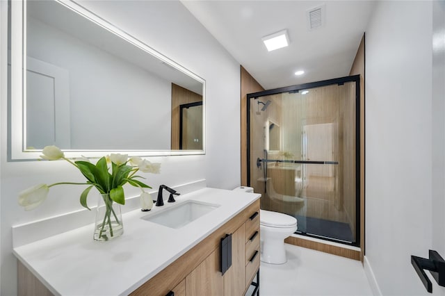 bathroom with visible vents, toilet, a stall shower, and vanity