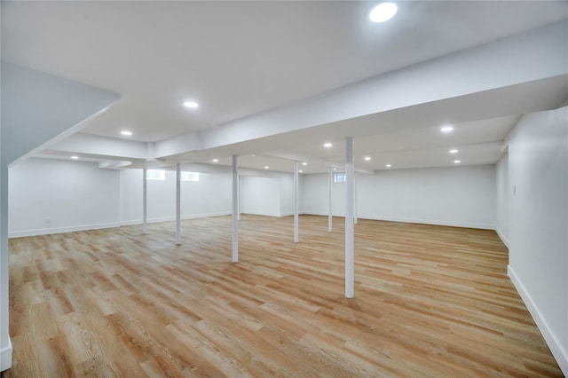 finished below grade area featuring recessed lighting, baseboards, and light wood-style floors