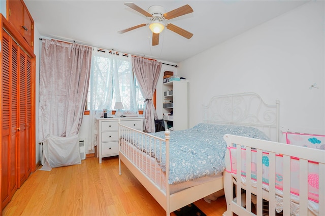 bedroom with a closet, light wood-style flooring, and a ceiling fan