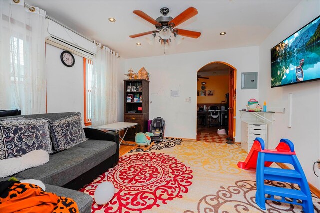 living room featuring electric panel, recessed lighting, arched walkways, a wall mounted AC, and a ceiling fan