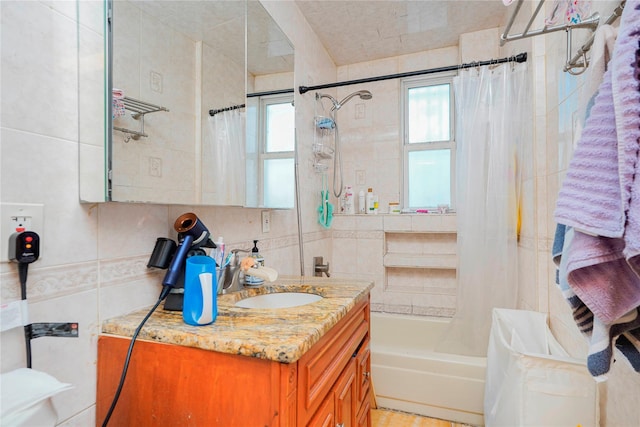 full bathroom with decorative backsplash, tile walls, and vanity