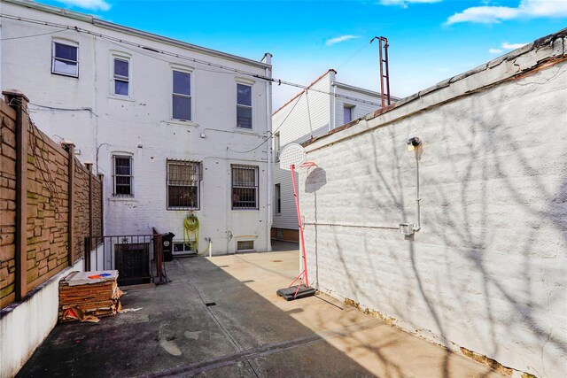 rear view of property with brick siding, a patio, and a fenced backyard