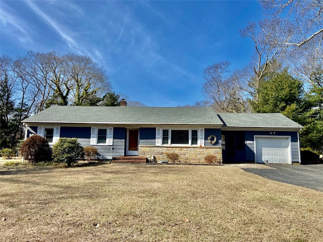 ranch-style house with a front lawn, aphalt driveway, roof with shingles, a chimney, and an attached garage