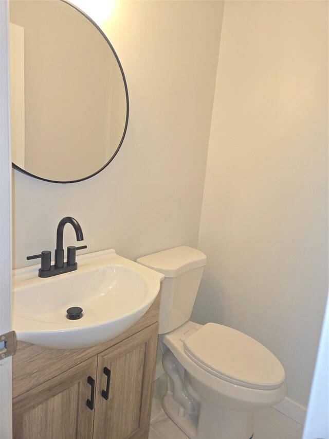 half bathroom with toilet, vanity, and tile patterned flooring