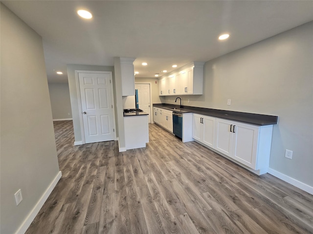 kitchen with white cabinetry, recessed lighting, a sink, dishwasher, and dark countertops