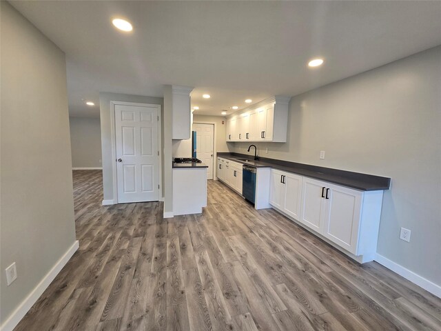 kitchen with recessed lighting, a sink, white cabinets, dishwasher, and dark countertops