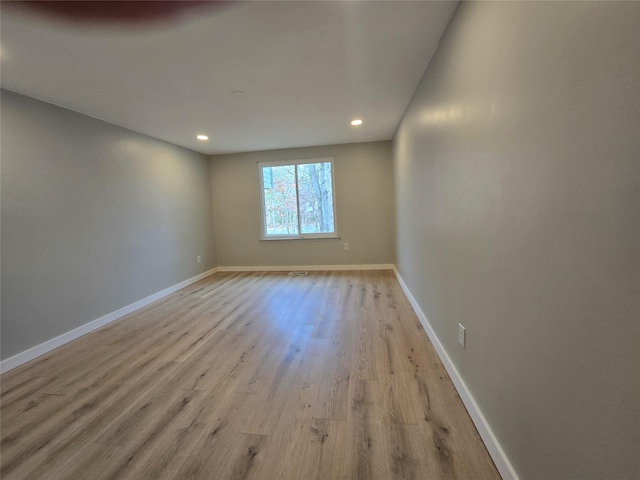 empty room featuring recessed lighting, baseboards, and wood finished floors