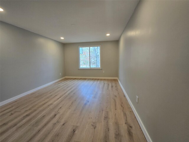 spare room with recessed lighting, light wood-style floors, and baseboards