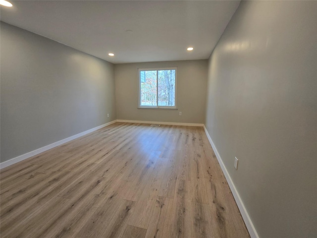 empty room with recessed lighting, baseboards, and wood finished floors