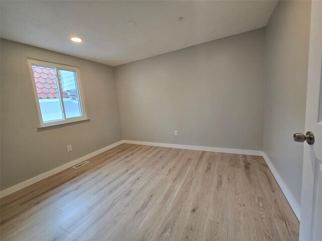 unfurnished room with recessed lighting, visible vents, light wood-style flooring, and baseboards