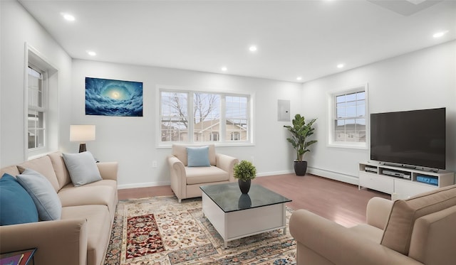 living room featuring plenty of natural light, recessed lighting, and baseboard heating