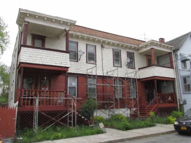 italianate house featuring a balcony and covered porch