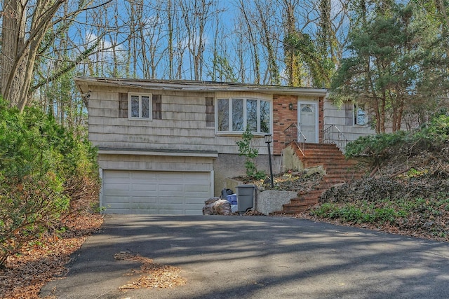 view of front facade with aphalt driveway and a garage