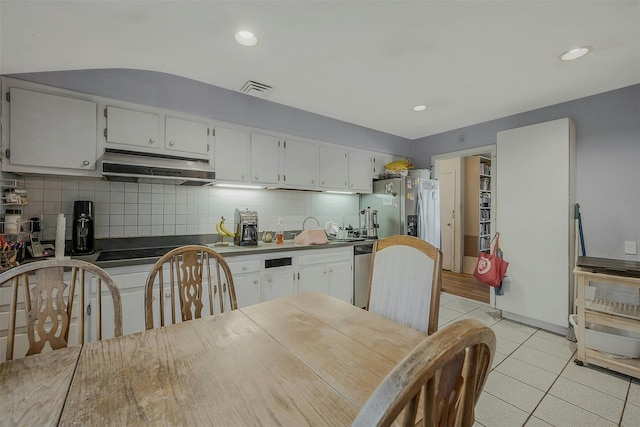 kitchen with visible vents, under cabinet range hood, stainless steel appliances, light tile patterned floors, and decorative backsplash