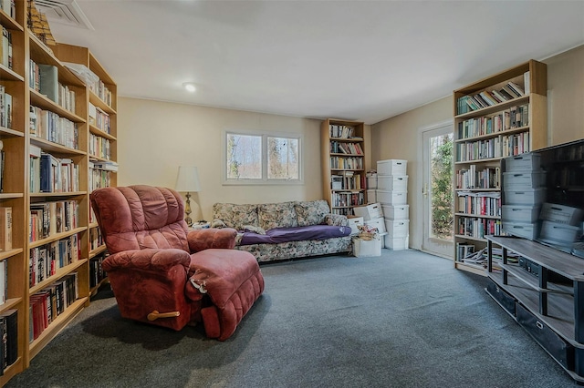 living area with carpet and wall of books