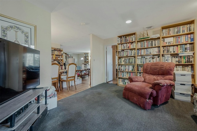 living area featuring carpet flooring, recessed lighting, and visible vents