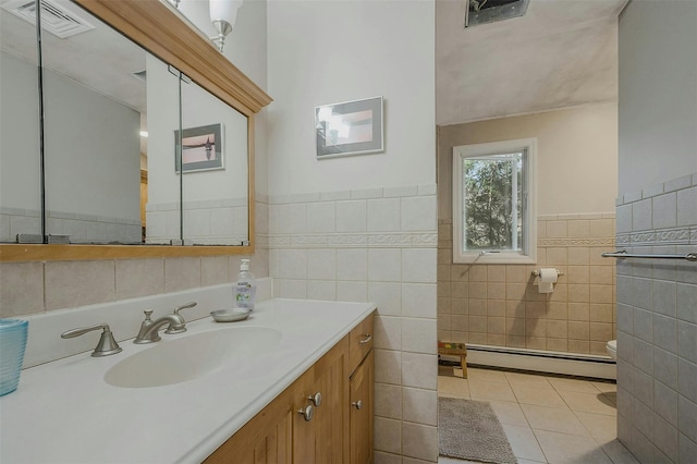 bathroom featuring visible vents, tile walls, tile patterned flooring, a baseboard radiator, and vanity